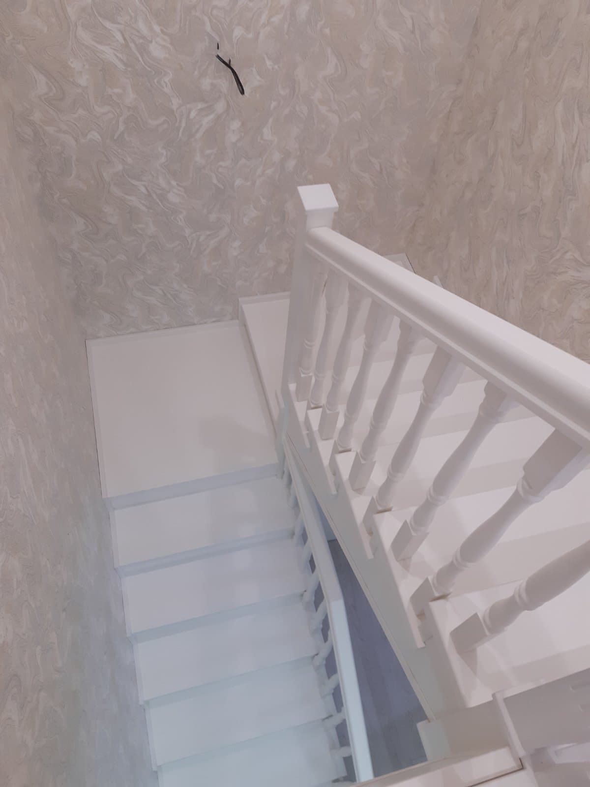 Вид со второго этажа на лестницу на металлокаркасе с двумя поворотными площадками