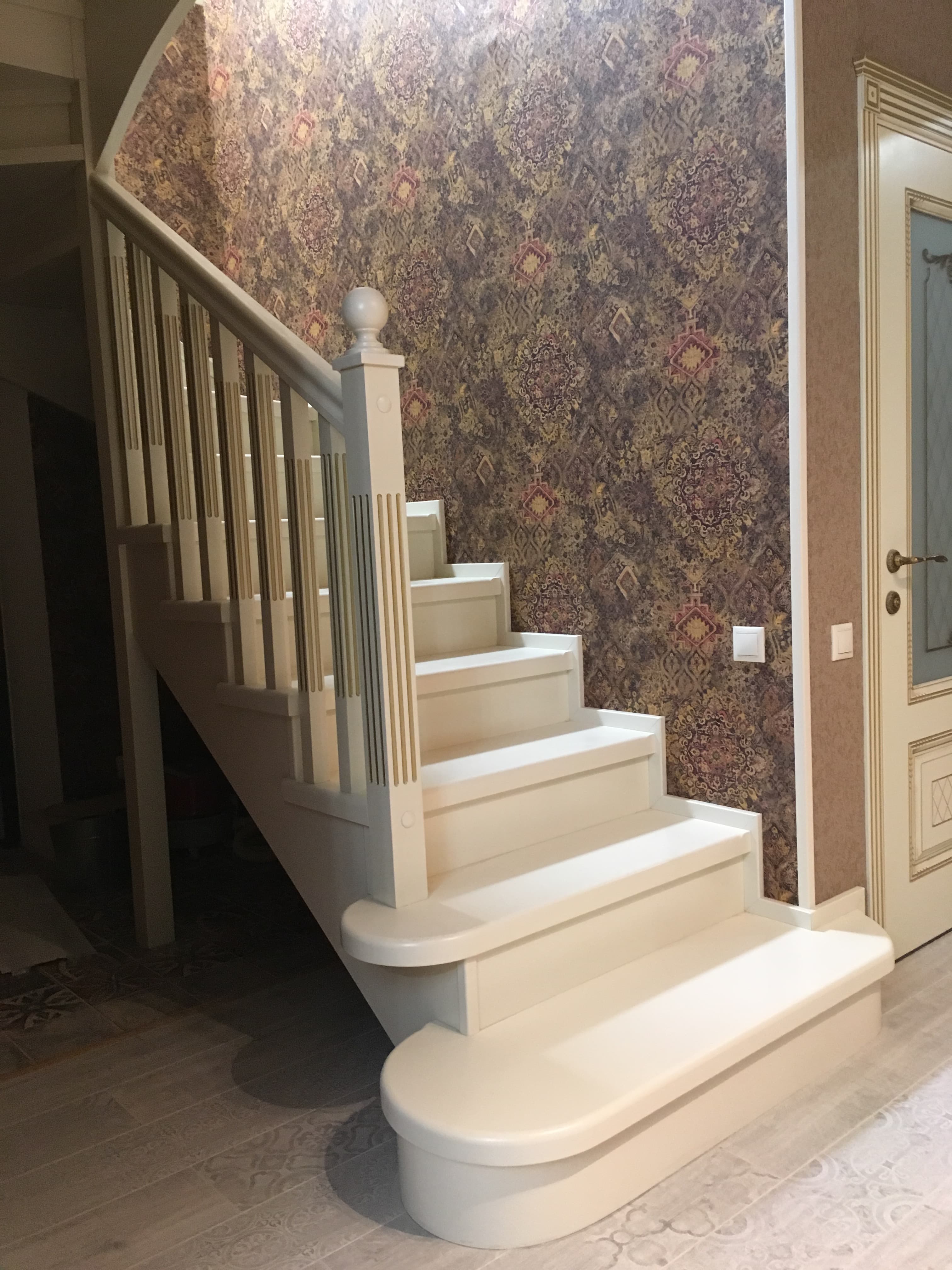 Деревянная лестница аккуратно прилегает к стене в классическом интерьере дома