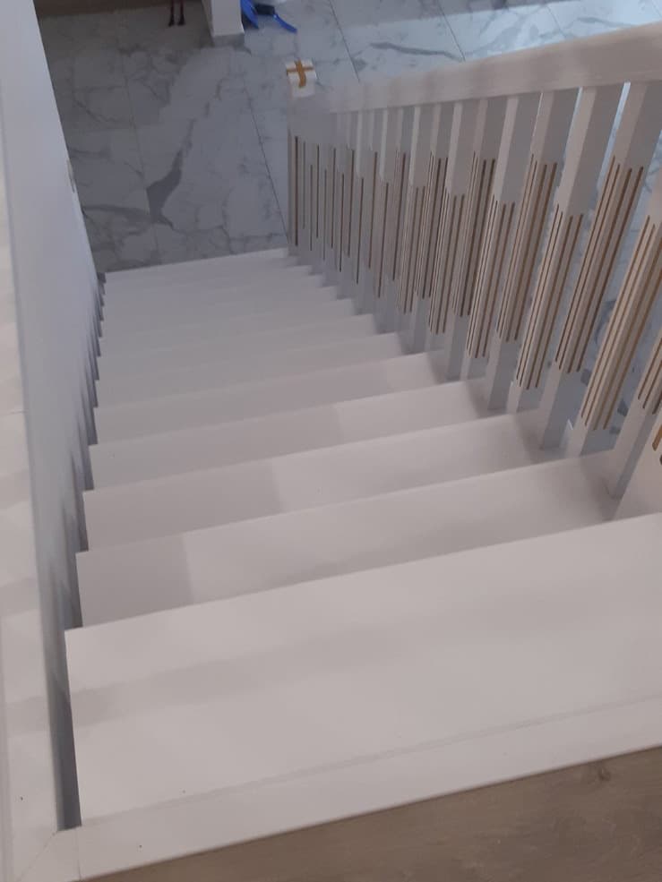 Вид со второго этажа на прямую лестницу на металлокаркасе в квартире