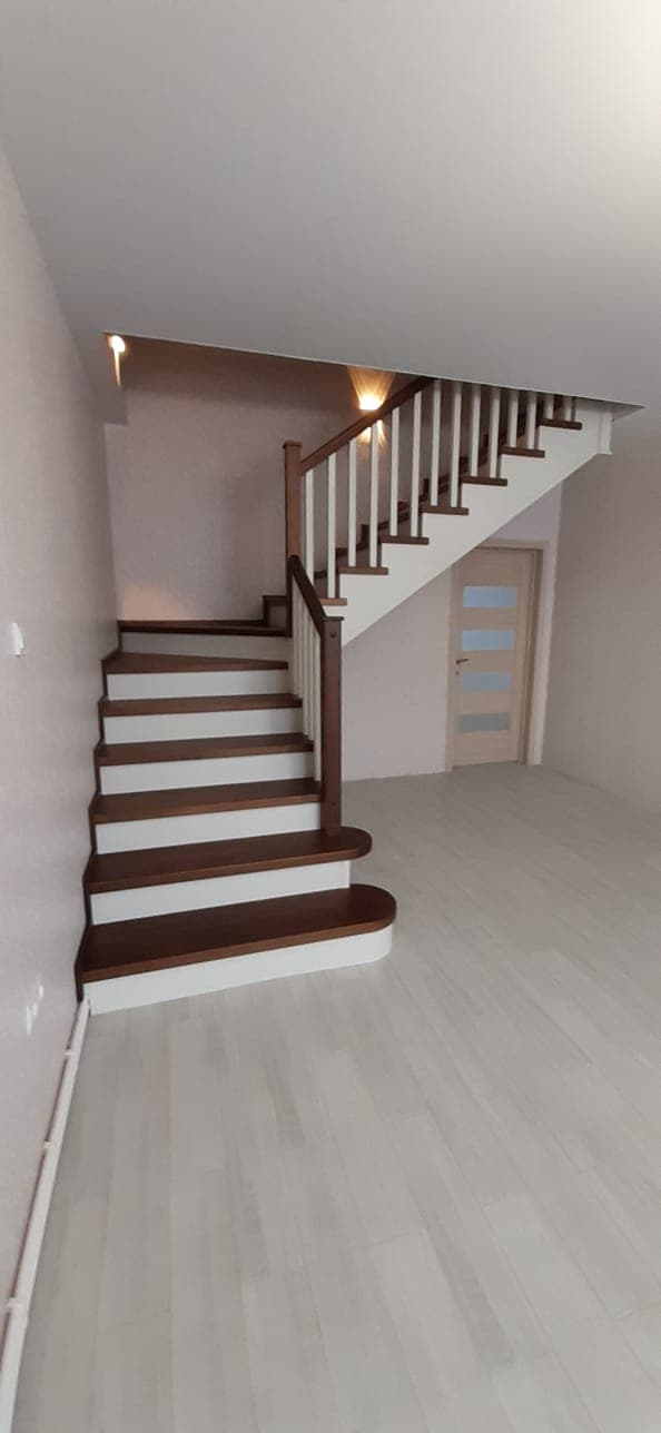 Лестница с поворотом с забежными ступенями в интерьере