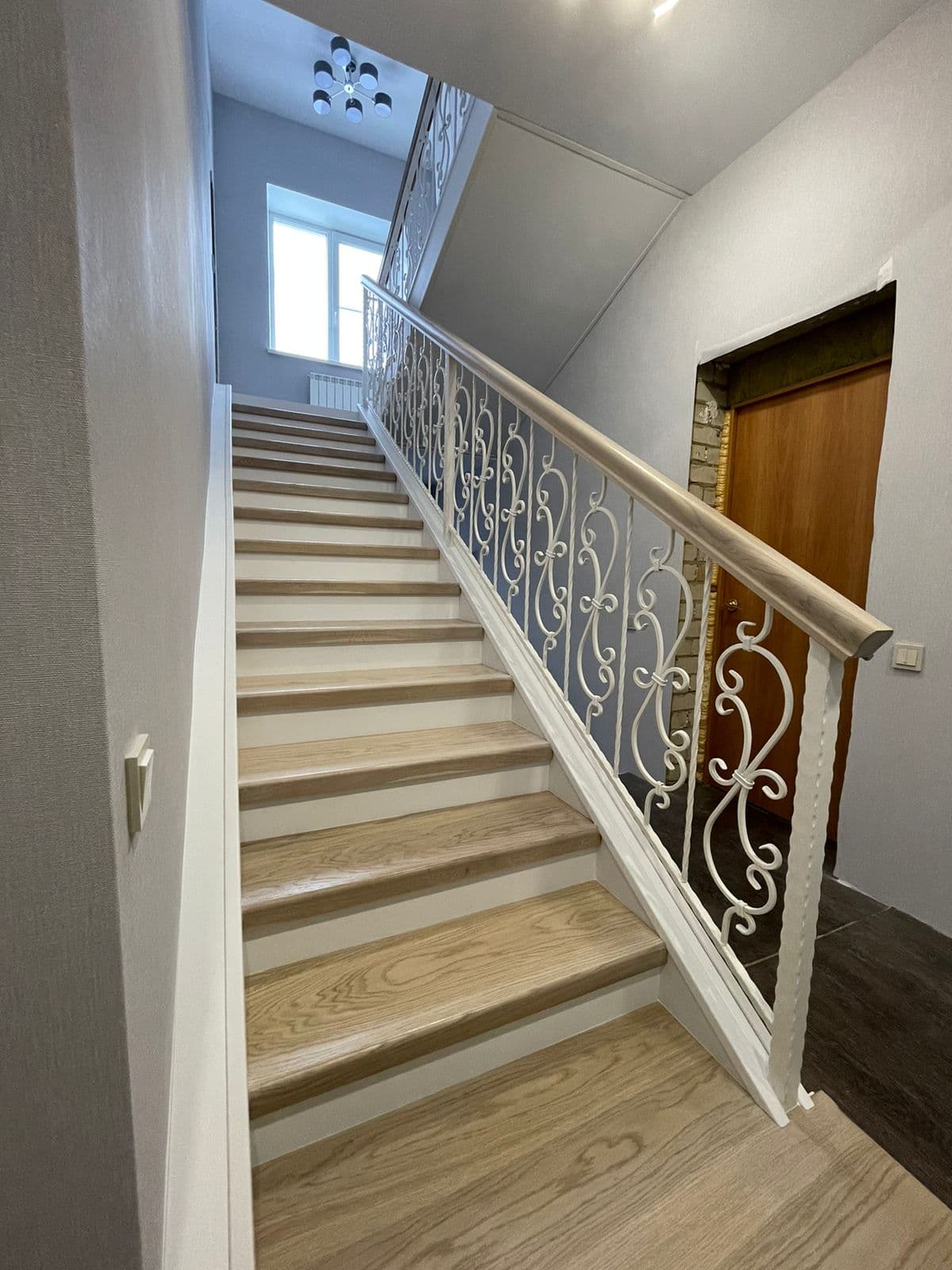 Вид на лестницу на металлических тетивах с первого этажа