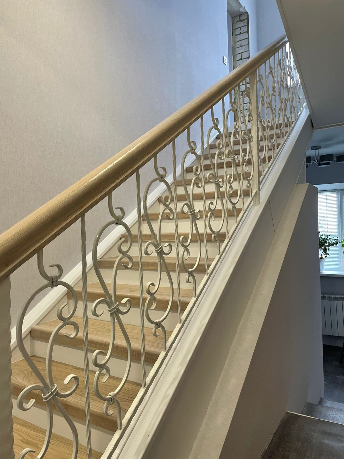 Красивые кованые балясины в белой эмали в сочетании с массивным поручнем