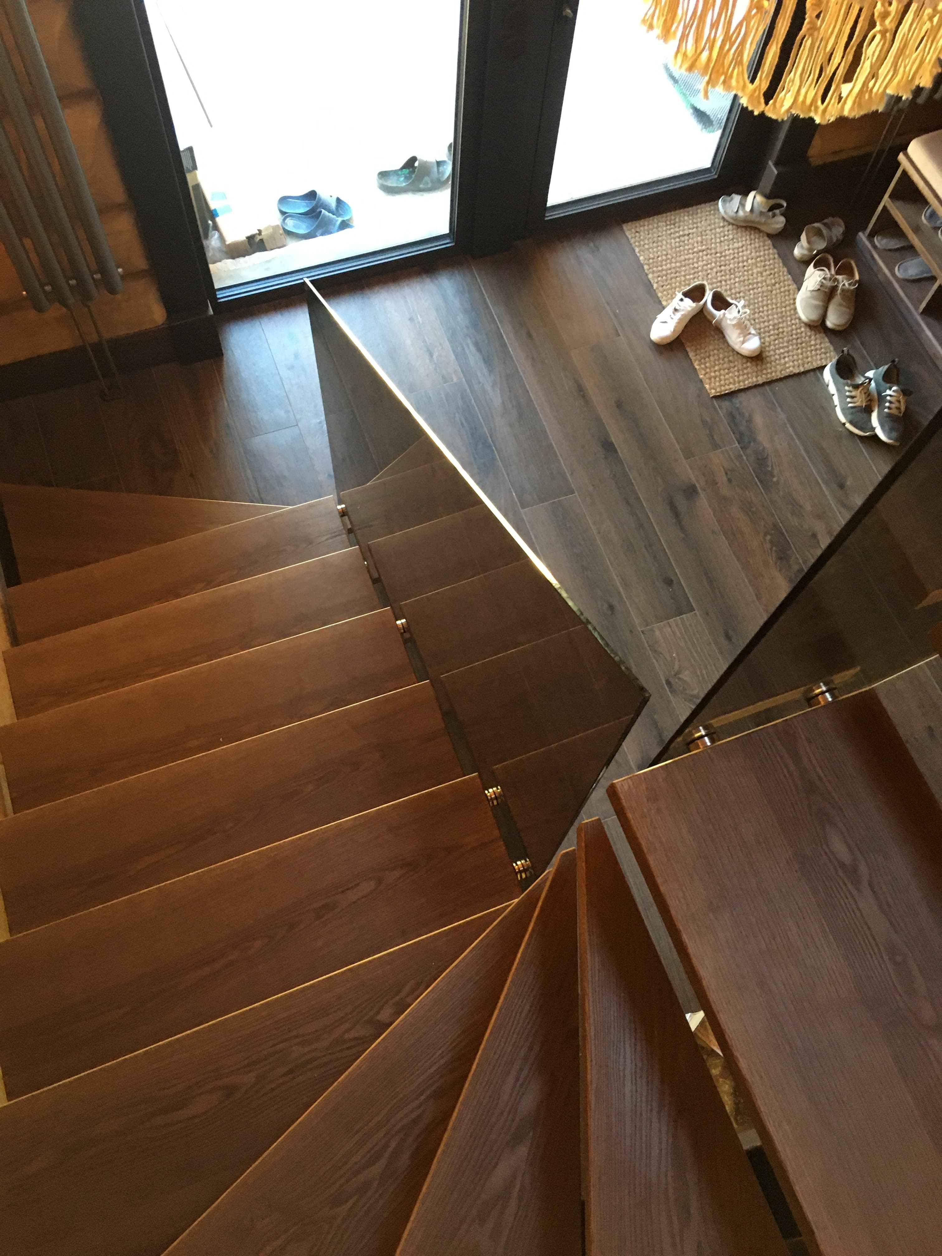 Лестница на металлическом монокосоуре с забежными ступенями и стеклянным ограждением