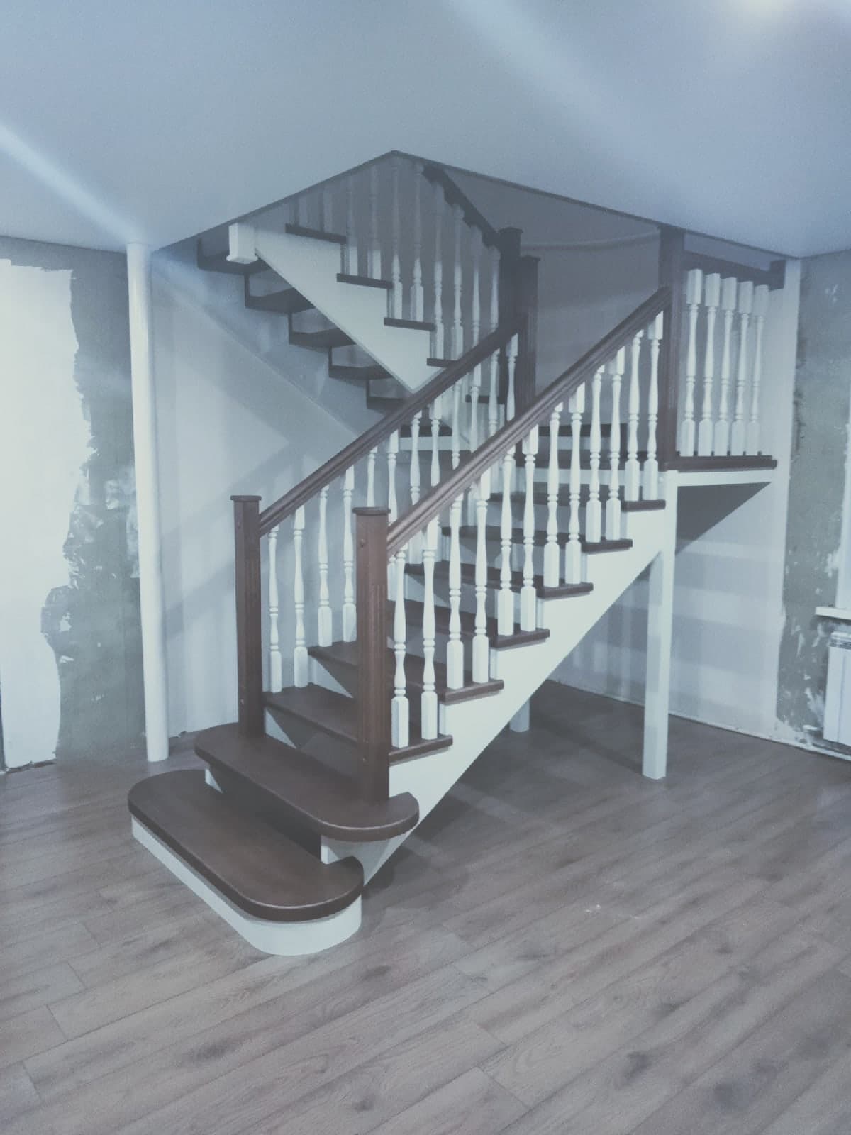 Вид сбоку на разворотную лестницу на второй этаж с двумя площадками