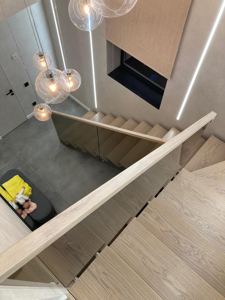 Лестница на металлическом монокосоуре со стекляным ограждением вид со второго этажа