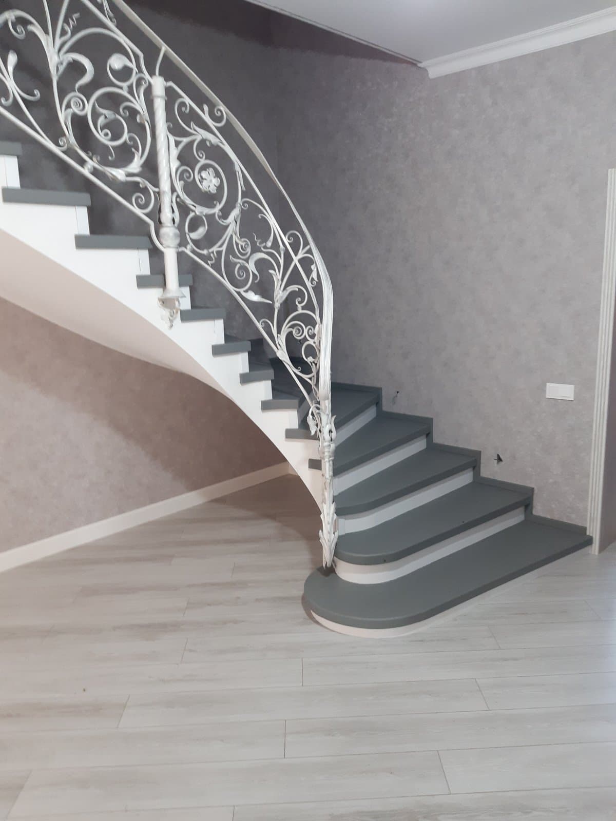 Общий вид на изгибы лестницы в интерьере с первого этажа