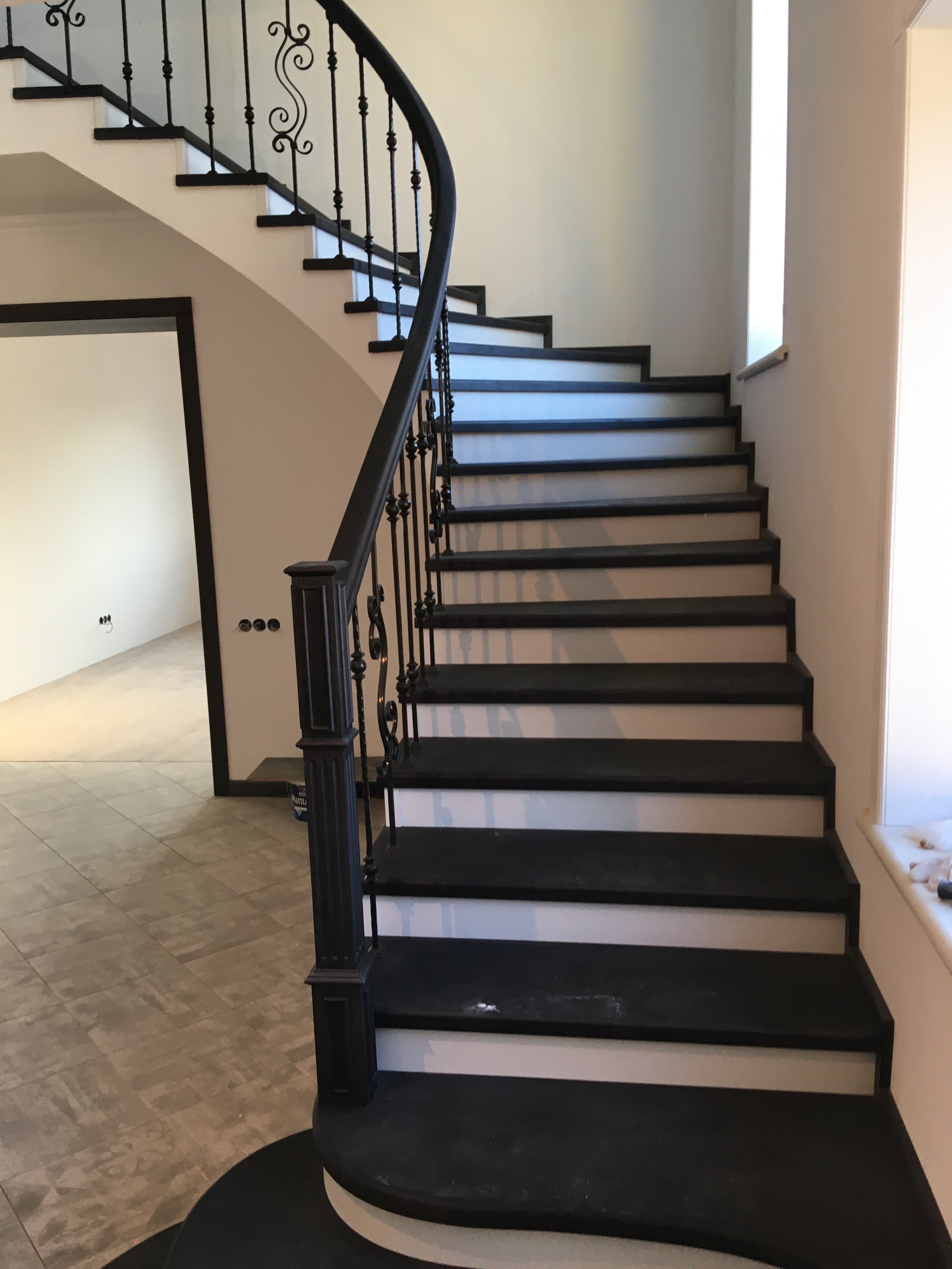 Поворот бетонной лестницы с дубовыми ступенями и выход на второй этаж