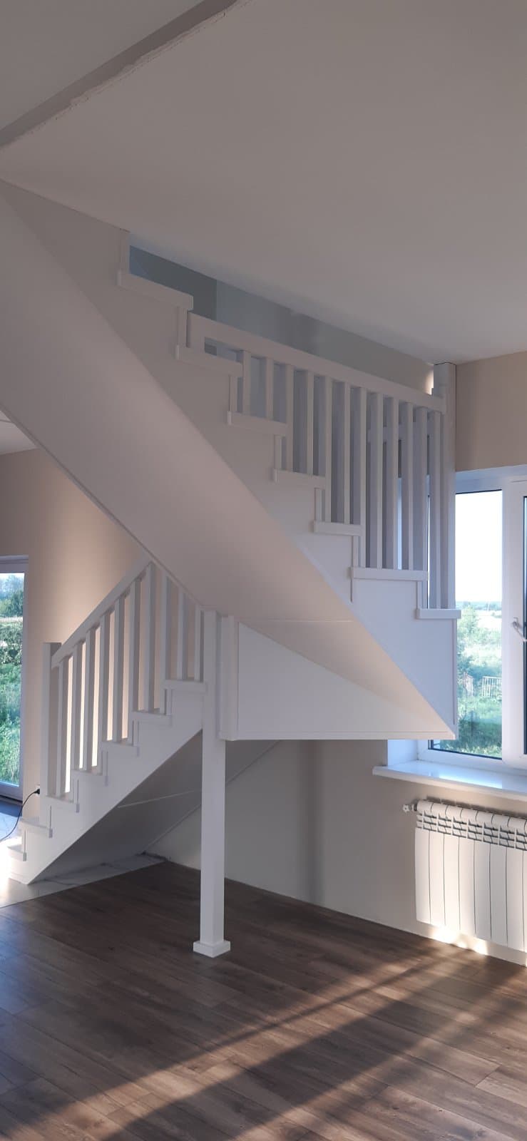 Белая лестница на металлокаркасе в светлом интерьере