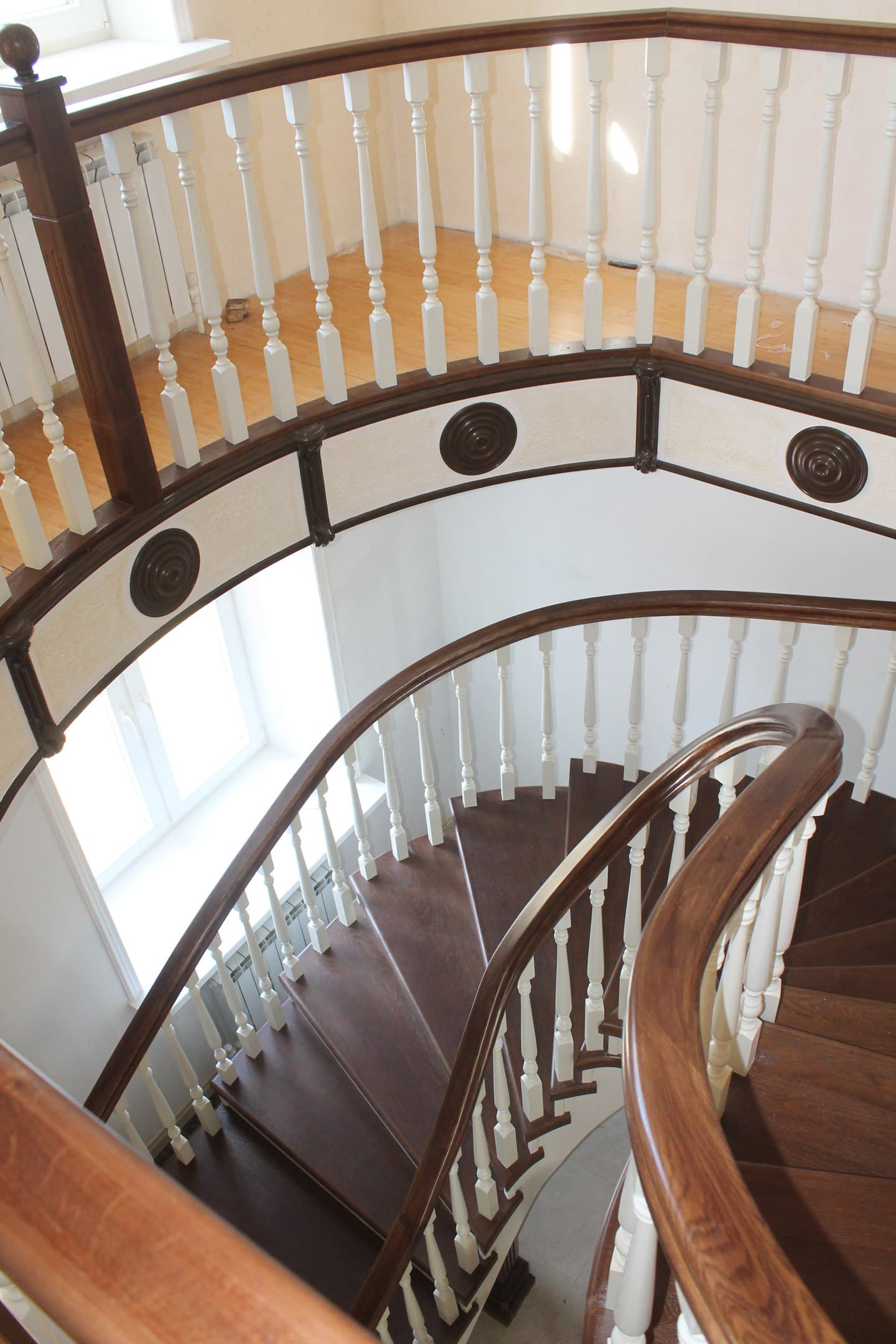 Изящный поручень изгибается на уровне второго этаже на лестнице
