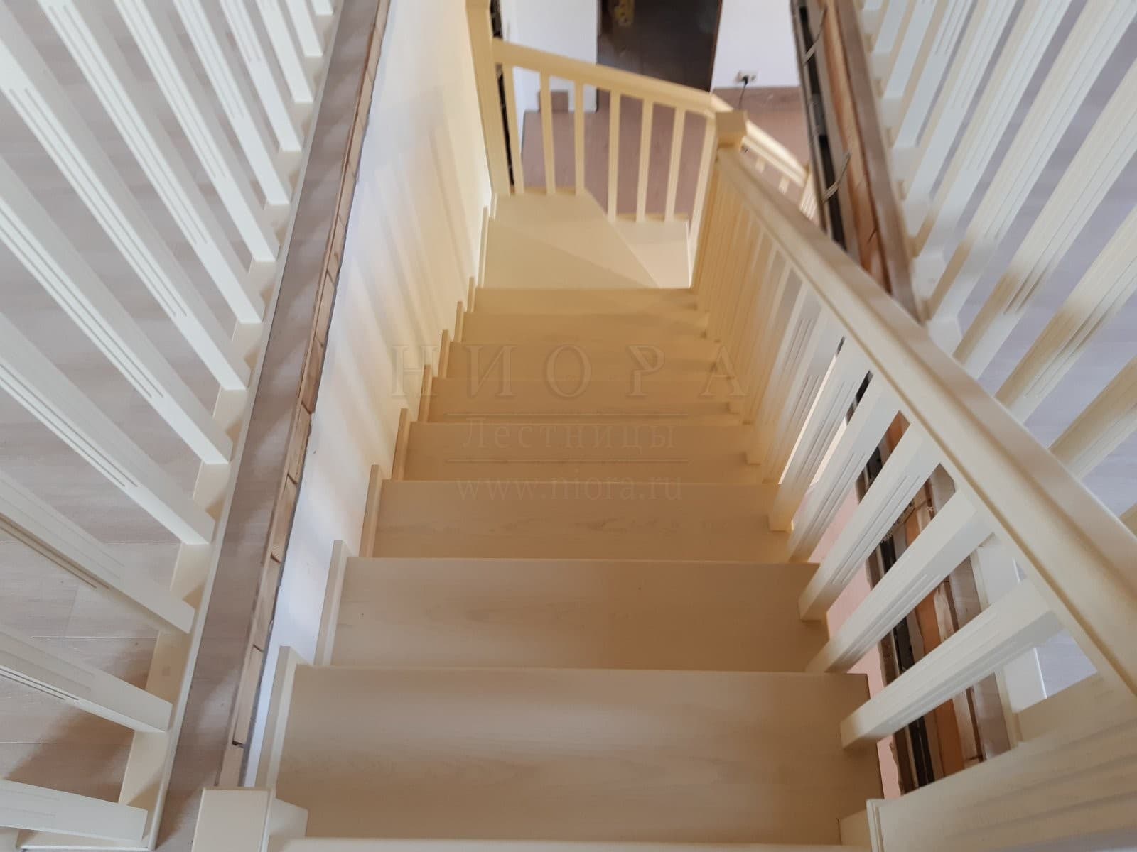 Вид со второго этажа на деревянную лестницу бежевого цвета
