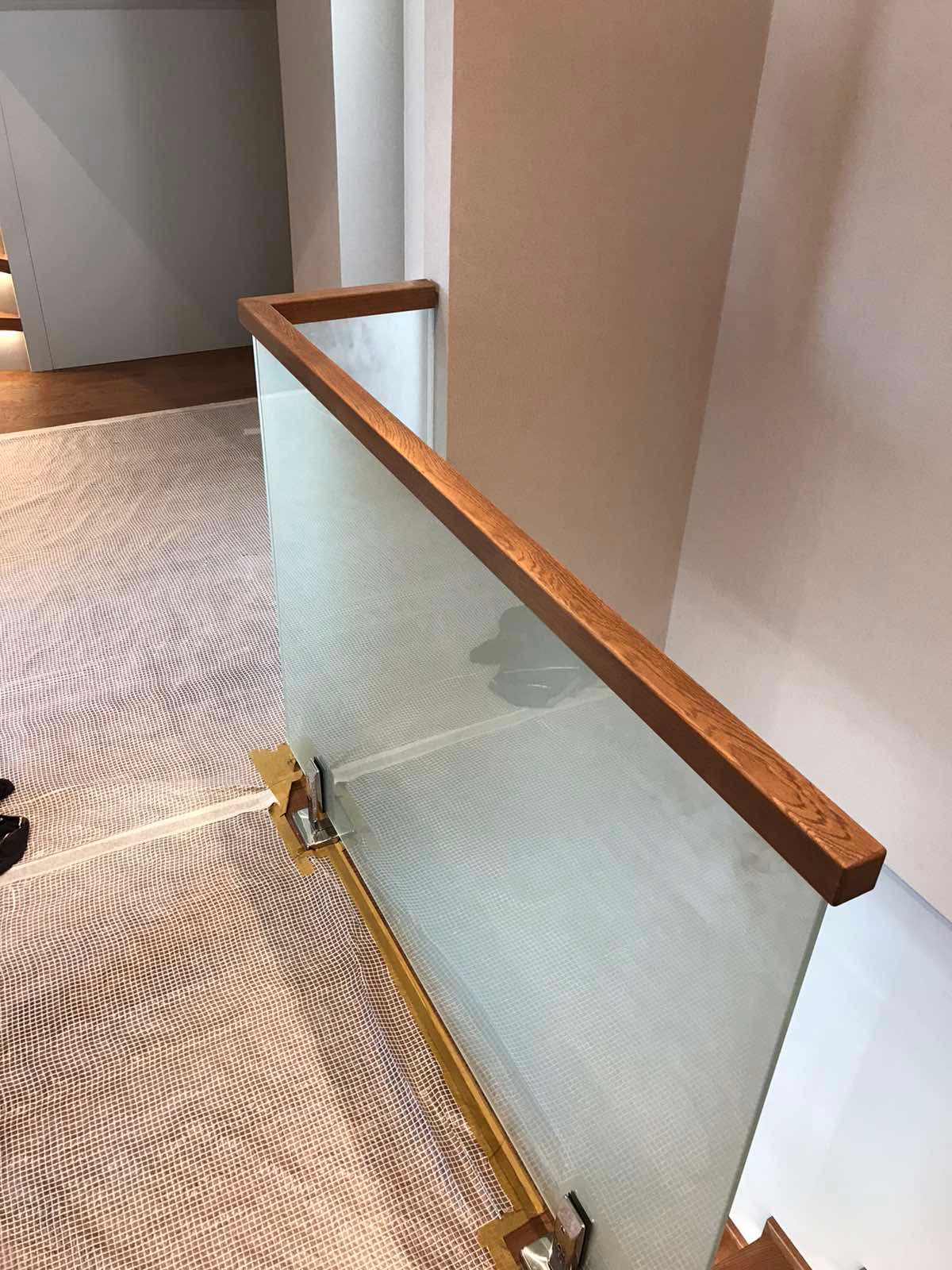 Аккуратный квадратный поручень на стеклянном ограждении лестницы