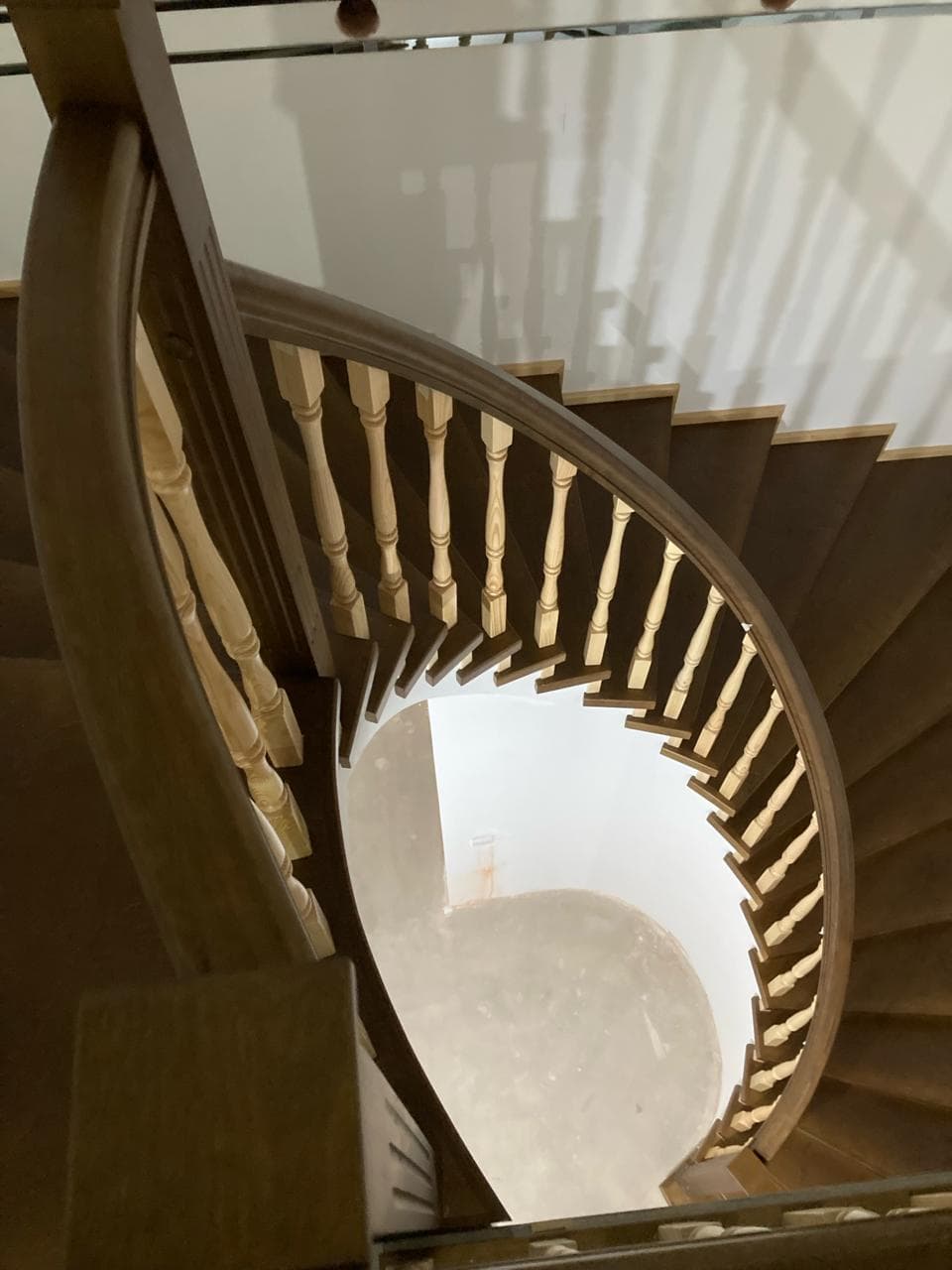 Спиральная лестница в березовой отделке и гнутый поручень вид со второго этажа
